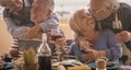 Old senior people and love friendship lifestyle celebration together in front of a table full of food and red wine. Happy retired