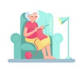 Old senior woman knitting while sitting in a chair