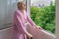 Senior woman looking at trees from her home balcony Royalty Free Stock Photo