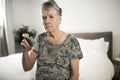 Old senior woman use inhaler medicine old asthma patient in bedroom