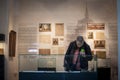 Old senior woman wearing a respiratory facemask observing art pieces in a museum exhibition during coronavirus covid 19 crisis