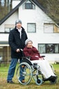 Old senior woman in wheelchair with careful son Royalty Free Stock Photo