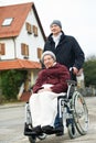 Old senior woman in wheelchair with careful son Royalty Free Stock Photo