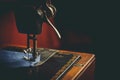 Old sewing machine, the man who sews on it, in dark colors Royalty Free Stock Photo