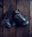 Old shabby black leather boxing gloves hanging on a nail Royalty Free Stock Photo