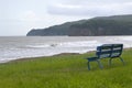 Old shabby blue bench on the shore of Japanese sea on a summer dull day before rain. No people