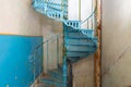 Old shabby blue metal spiral staircase in the interior of the Sharovsky castle, Ukraine Royalty Free Stock Photo