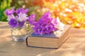 Old shabby book and flowers on the table