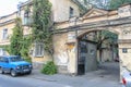 An old shabby building with an arch to the courtyard in Odessa. A car is parked nearby. The house is covered with ivy Royalty Free Stock Photo