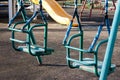 Old shabby empty swings at children playground. Loneliness, sadness, abandonment concept.