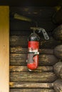 An old, shabby fire extinguisher mounted on a wall of a wooden building Royalty Free Stock Photo