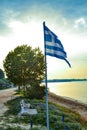 Old shabby tattered flag Geoponika beach on sunrise Aegean Sea North Greece Royalty Free Stock Photo