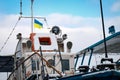 Old shabby flag of Ukraine waving over a ship against a blue sky