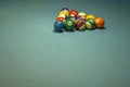 Old shabby multicolored billiard balls on a blurred blue cloth