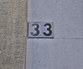 Old shabby numbers thirty-three, or 33. Written in black, half-faded paint Royalty Free Stock Photo