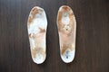 Old, shabby orthopedic insoles on the table