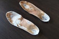 Old, shabby orthopedic insoles on the table