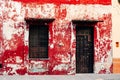 Old shabby red house with a brown door in Merida, Yucatan - december, 2019