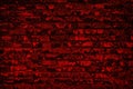 Old shabby scarlet colour painted brick wall. Aged bright red brickwork texture. Dark grunge background Royalty Free Stock Photo