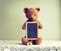 Old shabby toy bear with photo frame Royalty Free Stock Photo