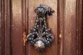 Old shabby vintage metal door knocker in the wooden door Royalty Free Stock Photo