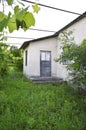 an old shabby wooden door and a yard overgrown with large grass Royalty Free Stock Photo