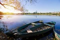 Old shabby worn green wooden boats enjoy summer sunrise at river bank in shade of willow tree, rural village seasonal ecotourism