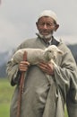 Old shepherd holding a baby goat Royalty Free Stock Photo