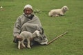 Old shepherd holding a baby goat