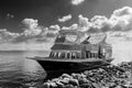 Old ship near stony shore floating in sea water near rocky coast against cloudy sky Royalty Free Stock Photo