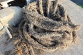 Old ship ropes pile for towing ship on cement flooring closeup at the port. Royalty Free Stock Photo