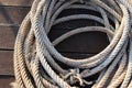 Old ship ropes pile for towing ship on wooden flooring closeup at the port. Royalty Free Stock Photo