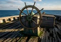 Old Ship Wheel on Decaying Deck by the Sea Royalty Free Stock Photo