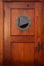 Old ship wooden door with porthole. Vintage sailing boat crew cabin entrance with round window. Beautiful sea and yacht concept Royalty Free Stock Photo