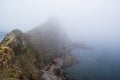 An old shipwrecked ship stands on the shore at the foot of a rocky cliff. Cape Briner. Primorsky Krai. Russia