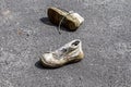 Concept of old shoes left on an ashpalt road with copy space for text Royalty Free Stock Photo