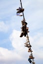 Old Shoes hanging on electrical wire against a blue sky Royalty Free Stock Photo