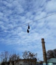 Old shoes hanging on a wire against a bright blue sky. Royalty Free Stock Photo