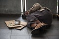 Old sick beggar or Homeless dirty man sleep on footpath with donate bowl, dollar bill, coin, paper cardboard with help text. Royalty Free Stock Photo
