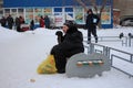 A sick old man man tired of sitting on the bench in the winter