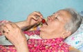 Old sick woman eating strawberry