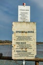 Old sign on the beach marking the free zone