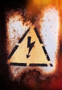 Old sign of danger of electric shock covered with rust. Royalty Free Stock Photo