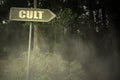 Old signboard with text cult near the sinister forest Royalty Free Stock Photo