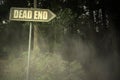 Old signboard with text dead end near the sinister forest Royalty Free Stock Photo