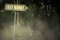 Old signboard with text easy money near the sinister forest Royalty Free Stock Photo