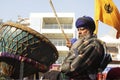An old sikh gentleman beating a huge drum Nagara
