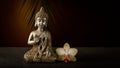 Old silver color statuette Buddha sitting in meditation pose with orhid flower