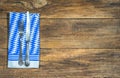 Old silver cutlery and bavarian napkin on rustic wooden table. Royalty Free Stock Photo