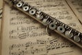 Old silver flute on vintage music notes